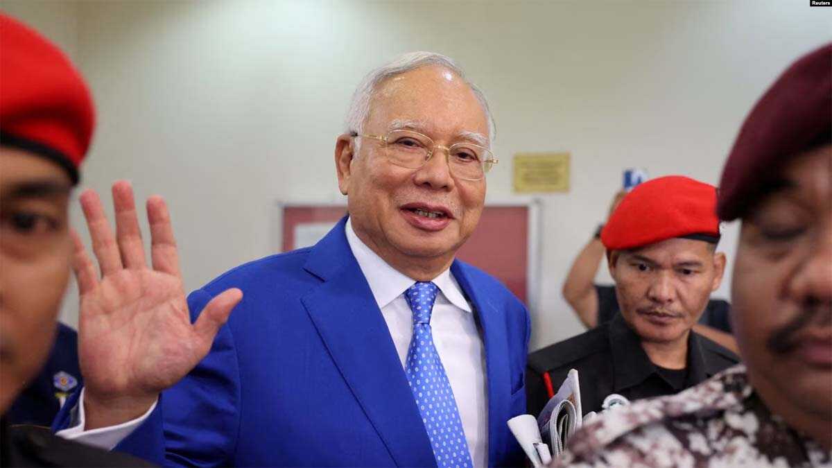 hukuman najib razak FILE: Mantan Perdana Menteri Malaysia Najib Razak dikawal oleh petugas penjara, melambaikan tangannya ke arah fotografer saat meninggalkan pengadilan seusai sidang di pengadilan Kuala Lumpur, Malaysia, 19 Januari 2024. (REUTERS/Hasnoor Hussain)