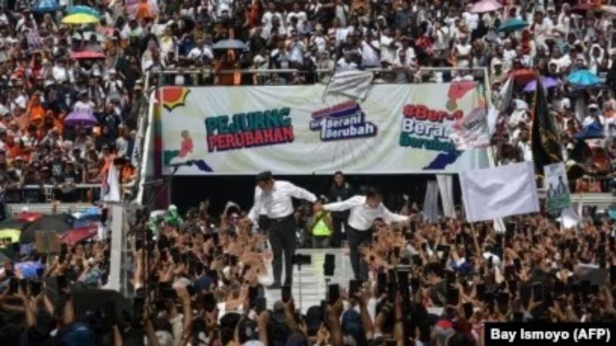 Calon presiden dan wakil presiden, Anies Baswedan (kiri) dan Muhaimin Iskandar, menyapa pendukungnya saat kampanye di Jakarta International Stadium, Jakarta pada 10 Februari 2024. (Foto: AFP/Bay Ismoyo)