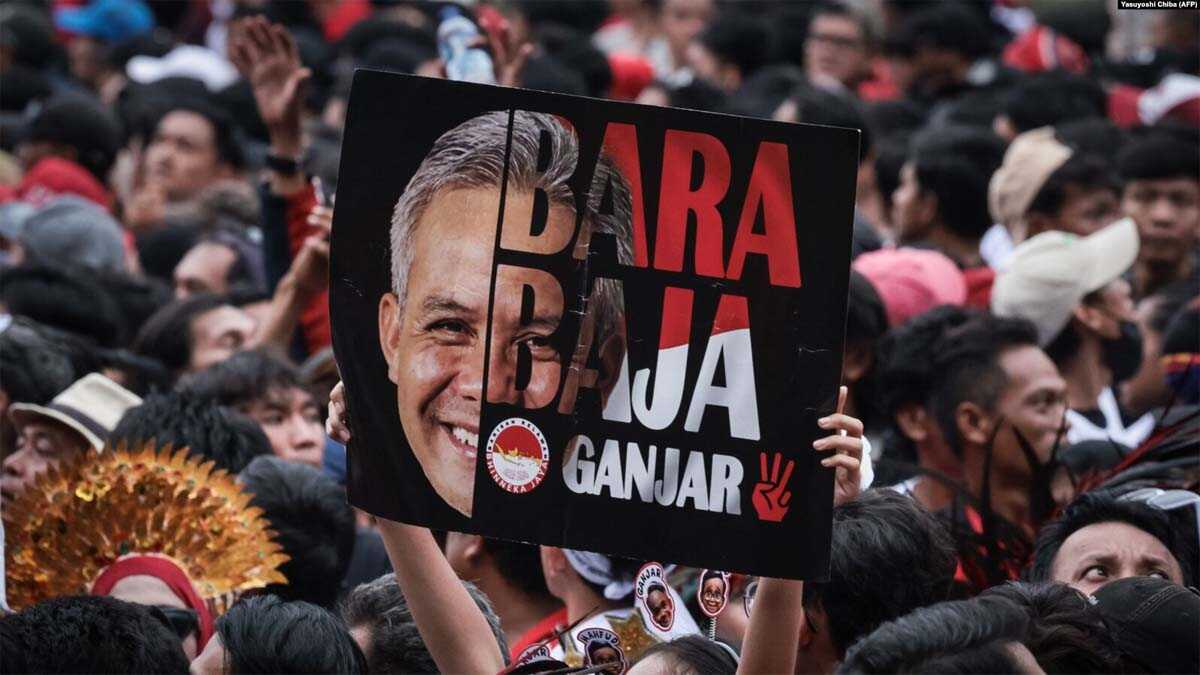 Seorang pendukung mengangkat poster calon presiden dan mantan gubernur Jawa Tengah Ganjar Pranowo saat kampanye pemilu di Stadion Gelora Bung Karno, Jakarta pada 3 Februari 2024. (Foto: Yasuyoshi Chiba/AFP)