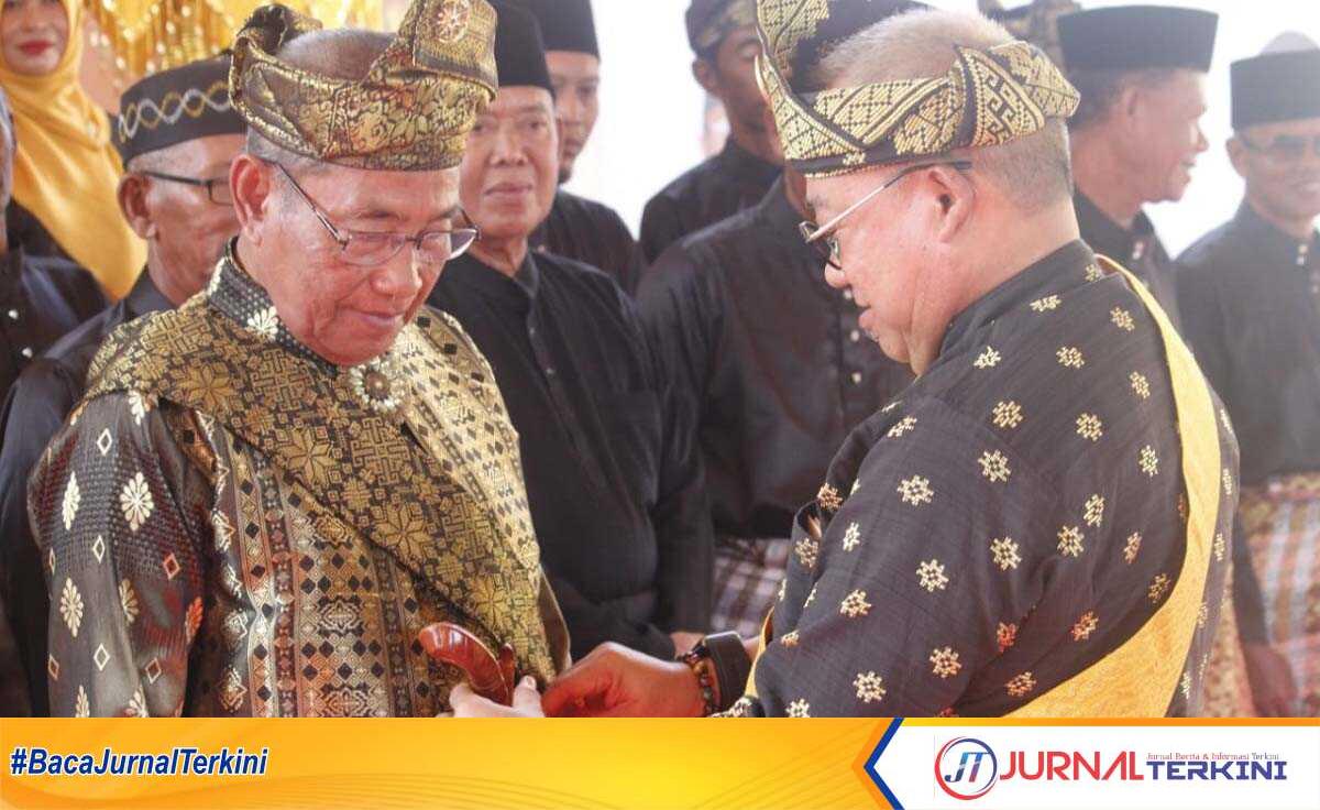 Ketua Lembaga Adat Melayu (LAM) Kabupaten Karimun-Kepri Muhammad Firmansyah menyarung keris kepada Ketua LAM Kecamatan Meral Barat Burhanuddin M Ali yang dilantik di Kelurahan Darussalam pada Senin (19/2/2024). (jurnalterkini.id/yogi)