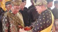 Ketua Lembaga Adat Melayu (LAM) Kabupaten Karimun-Kepri Muhammad Firmansyah menyarung keris kepada Ketua LAM Kecamatan Meral Barat Burhanuddin M Ali yang dilantik di Kelurahan Darussalam pada Senin (19/2/2024). (jurnalterkini.id/yogi)