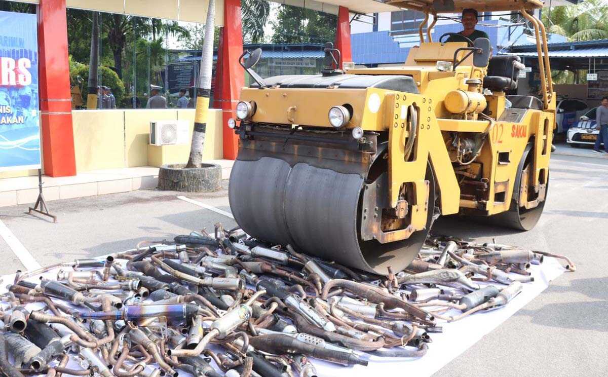 Ratusan knalpot brong berbunyi nyaring dimusnahkan dengan cara digilas menggunakan alat berat dalam kegiatan pemusnahan yang dilaksanakan di halaman Mapolres Karimun, Rabu (7/2/2024). (foto: Humas Polres Karimun/Helman)