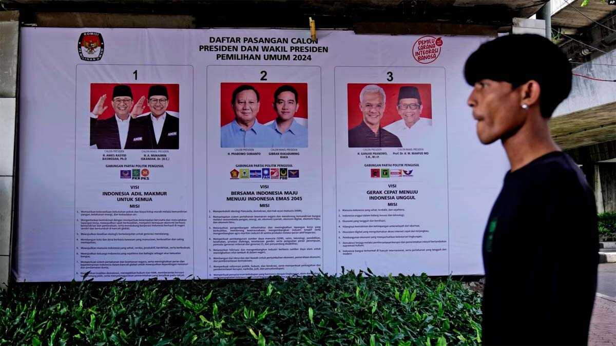 spanduk kpu Seorang pria berjalan melewati spanduk KPU yang memperlihatkan foto-foto calon presiden di Jakarta, 22 Januari 2024. Indonesia dijadwalkan mengadakan pemilihan presiden pada 14 Februari. (AP/Dita Alangkara)