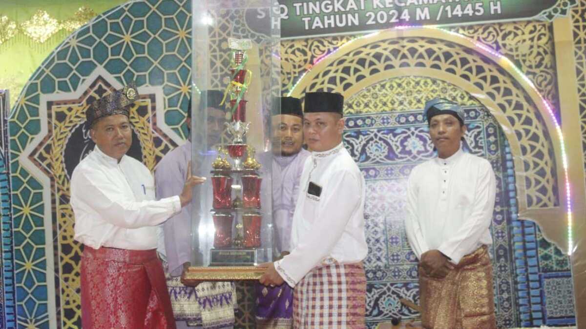 Camat Tebing Khaidir menyerahkan piala bergilir kepada panitia pelaksana MTQ tingkat Kecamatan Tebing dalam acara pembukaan, Rabu (21/2/2024). (jurnalterkini.id/edy kencana)
