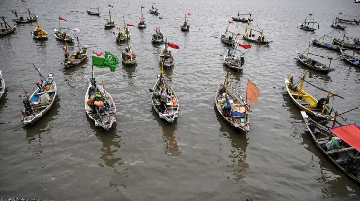 Nelayan di surabaya ILUSTRASI - Nelayan duduk di dermaga di samping perahunya pada libur Tahun Baru di Surabaya, 1 Januari 2024. (Juni Kriswanto/AFP)