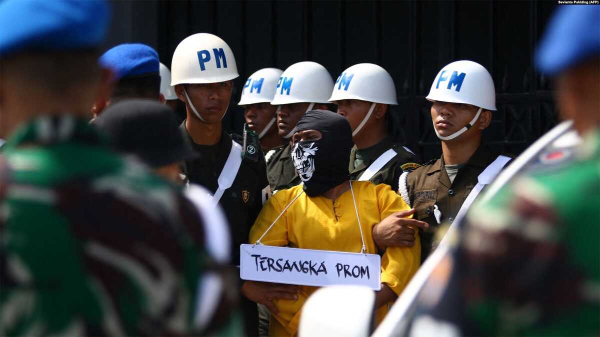 Polisi Militer mengawal satu dari enam tentara yang menjadi tersangka pembunuhan empat orang asli Papua untuk rekonstruksi di Mimika, Papua, 3 September 2022. (Foto: Sevianto Pakiding/AFP/arsip)