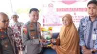 baza murah polres karimun Kapolres Karimun AKBP Fadli Agus menyerahkan beras dengan harga murah kepada salah seorang dalam bazar murah di Sei Lakam Barat, Kecamatan Karimun, Kamis (29/2/2024). (Foto: Humas Polres Karimun/Helman)
