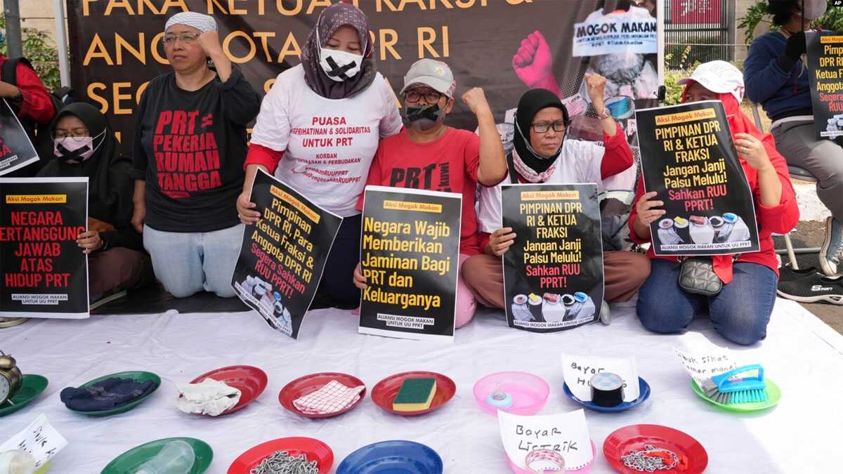 demo ruu prt di dpr Para aktivis membawa poster-poster dan memamerkan barang-barang rumah tangga dalam demo di depan gedung DPR/MPR untuk menuntut DPR agar mengesahkan RUU Perlindungan Pekerja Rumah Tangga menjadi undang-undang, Jakarta, 14 Agustus 2023. (Foto: Tatan Syuflana/AP Photo)