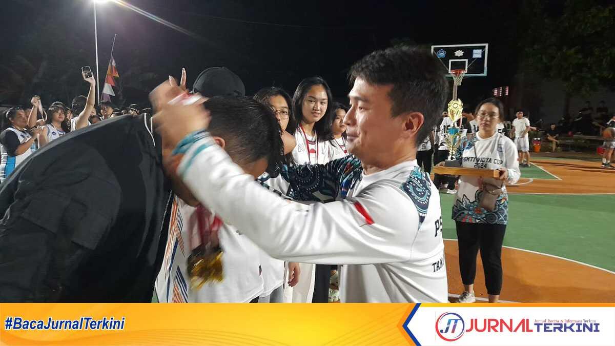 Ketua panitia, Awan mengalungkan medali kepada para juara dalam Turnamen Vidya Cup 2024 di halaman Sekolah Vidya Sasana, Jumat (1/3/2024) malam. (jurnalterkini.id/jansen)