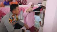 polres karimun peduli stunting-1 Ketua Bhayangkari Cabang Karimun Lya Fadli Agus didampingi Kapolres Karimun AKBP Fadli Agus mengukur lingkar kepala seorang balita di sela pemberian vitamin A untuk mencegah stunting di kalangan anak anggota polisi diselenggarakn di Posyandu Asrama Polisi, Kapling, Tanjung Balai Karimun, Selasa (27/2/2024). (jurnalterkini.id/jansen)