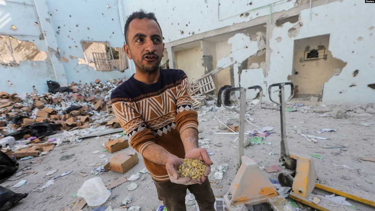 warga palestina menanti bantuan Seorang penduduk Palestina memegang bahan makanan mentah di tempat serangan Israel di gudang bantuan, yang terletak di kamp pengungsian Al-Nuseirat di Tengah Jalur Gaza, 14 Maret 2024. (Foto: REUTERS/Ahmed Zakot)