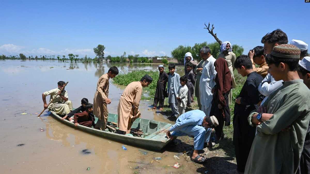 Warga yang mengungsi tiba dengan perahu melintasi daerah banjir setelah hujan lebat di distrik Nowshera, provinsi Khyber-Pakhtunkhwa, Pakistan Selasa, 16 April 2024. (foto: AFP)