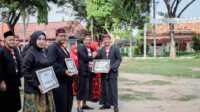 Pj Bupati Pamekasan, Masrukin, saat memberikan penghargaan kepada beberapa OPD di Kabupaten Pamekasan. (Dok. Prokopim)