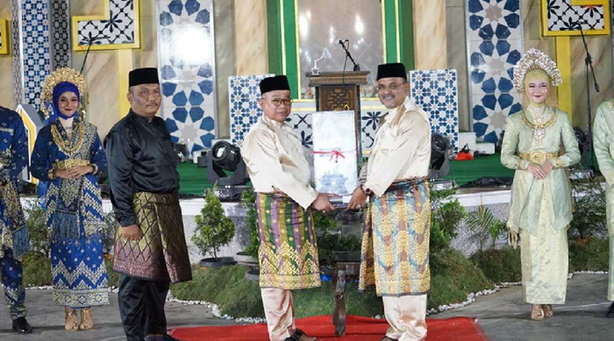 Ketua Umum Panitia MTQ XVI Kabupaten Karimun Muhammad Firmansyah (kiri) menerima piala bergilir untuk juara umum MTQ dari Bupati Aunur Rafiq dalam acara pembukaan di Coastal Area, Tanjung Balai Karimun, Selasa (16/4/2024) malam. (foto dokumentasi pribadi/eka)