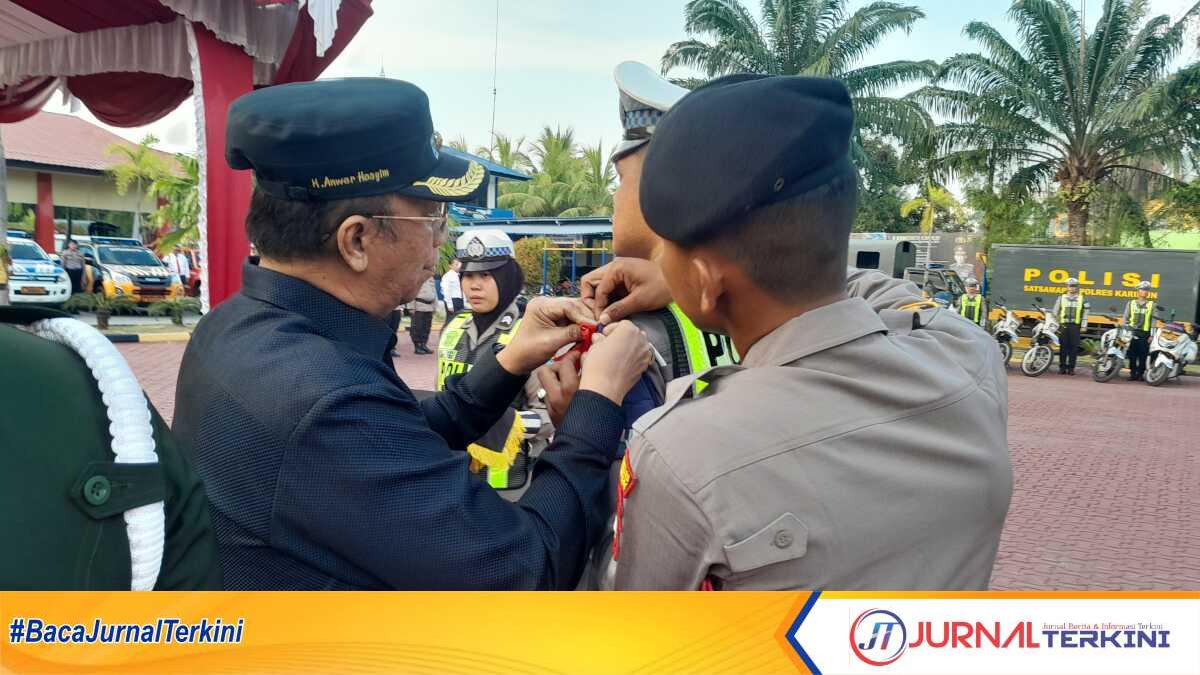 Wakil Bupati Karimun Anwar Hasyim menyematkan kepada personel yang terlibat dalam Operasi Ketupat Seligi 2024 dalam apel gelar pasukan di Mapolres Karimun, Rau (3/4/2024). (jurnalterkin.id/rusdi)