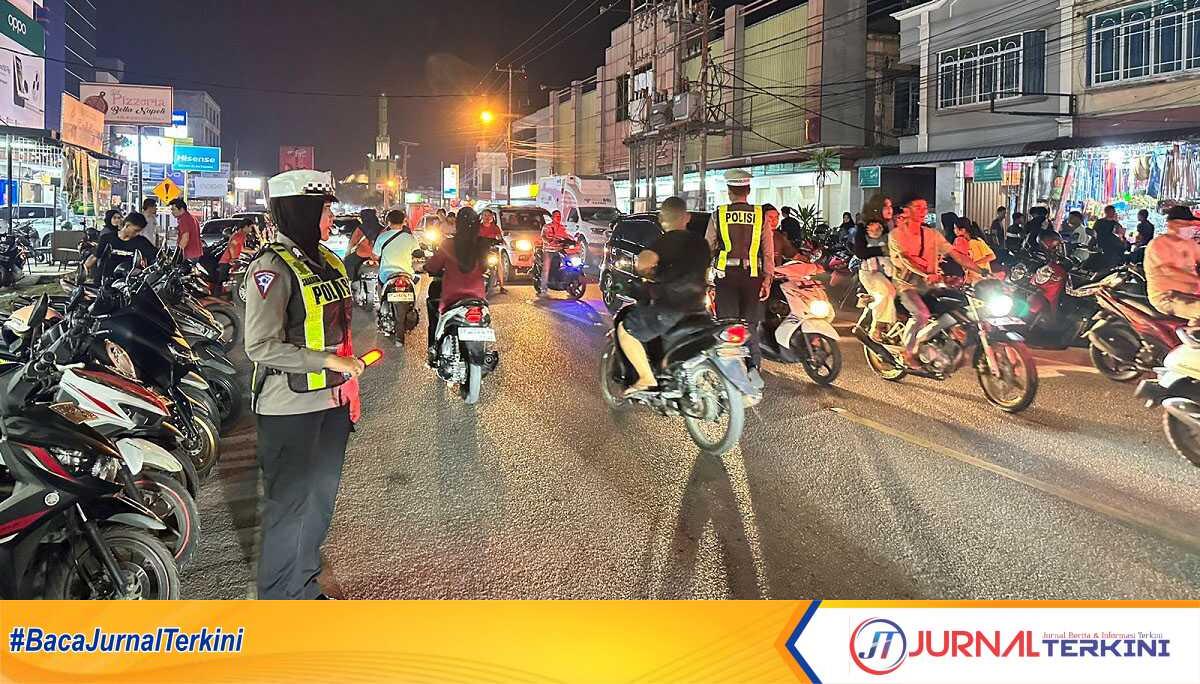 Seorang polwan mengatur arus lalu lintas di Jalan Nusantara, Tanjung Balai Karimun yang padat pada malam takbiran Idul Fitri, Selasa (9/4/2024). (jurnalterkini.id/jansen)