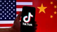 Logo TikTok terpampang di layar iPhone di depan latar bendera AS dan bendera Tiongkok di Washington, DC, pada 16 Maret 2023. (Foto: AFP)