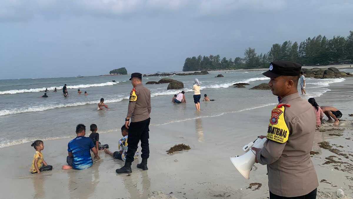 Personel Polsek Gunung Kijang menyampaikan imbauan dan tips kepada pengunjung Pantai Tergok agar aman menikmati libur akhir pekan, Sabtu (4/5/2024). (foto: Humas Polres Bintan)