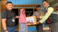 Chief Security G4S PT Saipem Elkan Tampubolon didampingi Bhabinkamtibmas Pangke Barat menyerahkan bantuan paket sembako kepada salah seorang warga, Selasa (14/5/2024). (jurnalterkini.id/jansen)