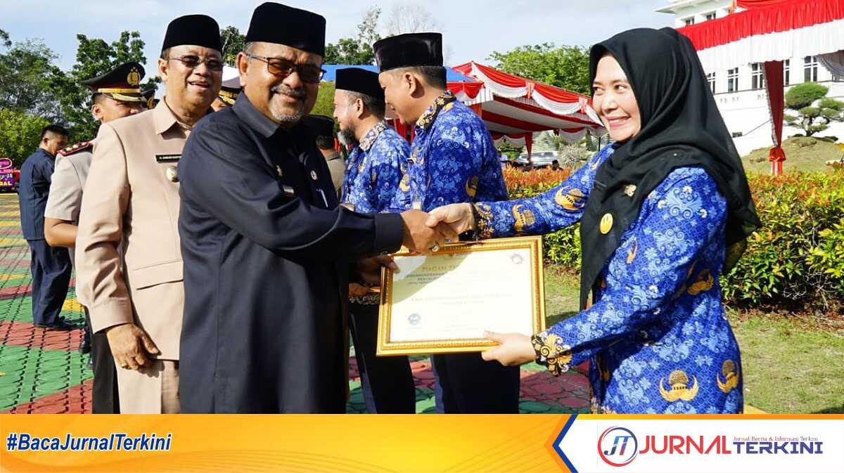 Bupati Karimun Aunur Rafiq didampingi Wakil Bupati Anwar Hasyim dan sejumlah pejabat menyerahkan piagam penghargaan kepada beberap OPD usai upacara Hari Otonomi Daerah ke-28 dan Hardiknas di Kantor Bupati Karimun, Kamis (2/5/2024). (jurnalterkini.id/edy)