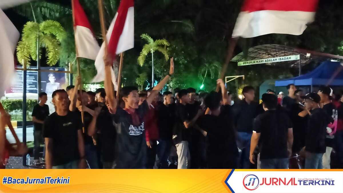Penonton mengibarkan bendera merah putih saat nonton bareng atau nobal semifinal Piala Asia AFC U-23 antara Indonesia melawan Uzbekistan di Mapolres Karimun, Senin (29/4/2024) malam.(jurnalterkini.id/edy kencana)