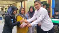 Dinas PUPR Karimun berkurban-1 Kepala Dinas Pekerjaan Umum dan Penataan Ruang (PUPR) Kabupaten Karimun, Cahyo Prayitno menyerahkan satu kantong daging kurban usai pemotongan hewan kurban di Taman Besembang, Kantor Dinas PUPR Karimun, Rabu (19/6/2024). (jurnalterkini.id/yogi)