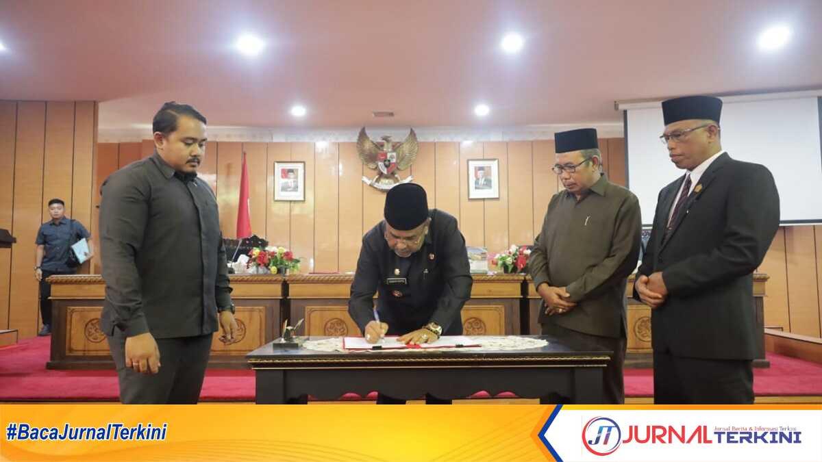 Bupati Karimun Aunur Rafiq disaksikan Ketua DPRD Karimun M Yusuf Sirat dan Wakil Ketua Hasanuddin menandatangani pengesahan Perda LKPJ APBD 2023 dalam rapat paripurna di gedung DPRD Karimun, Rabu (12/6/2024). (jurnalterkini.id/edy)