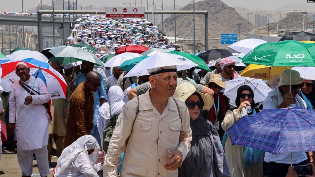 Para jemaah haji berjalan dengan payung di tengah cuaca yang sangat panas, di Mina, Arab Saudi, 18 Juni 2024. (Foto: REUTERS/Saleh Salem)