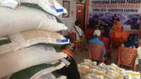 Petugas Kantor Pos Tanjung Balai Karimun melayani warga mendapatkan bantuan beras Bulog 10 Kilogram, Selasa (25/6/2024). (jurnalterkini.id/yogi)