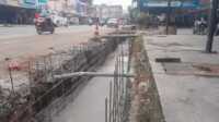 Penggalian drainase baru di sepanjang Jalan A Yani depan BSI, di samping drainase lama (kanan) yang sudah tertutup semen, dan didalamnya tertimbun tanah atau sampah. Foto diambil Sabtu (22/6/2024). (jurnalterkini.id/yogi)