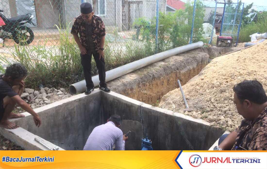 Direktur Perumda Tirta Mulia Karimun Herry Budhiarto (berdiri) mengamati petugas yang memperbaiki pipa yang mengalami kebocorandi Tanjung Balai Karimun, Kamis (7/6/2024). (jurnalterkini.id/yogi)