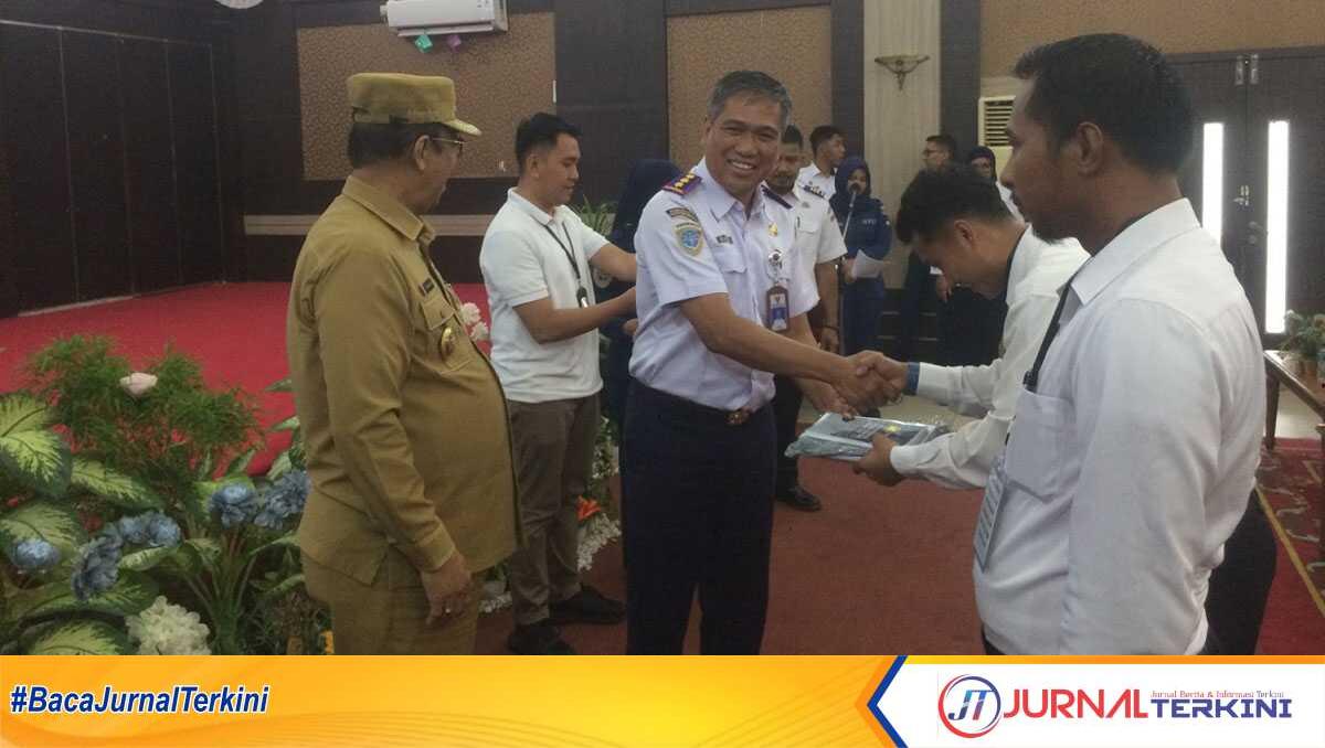 diklat transportasi laut ksop karimun Kepala KSOP Kelas I Tanjung Balai Karimun Supendi didampingi Wakil Bupati Karimun Anwar Hasyim menyerahkan materi diklat kepada para peserta di Gedung Nasional, Tanjung Balai Karimun, Senin (8/7/2024). (jurnalterkini.id/yogi)