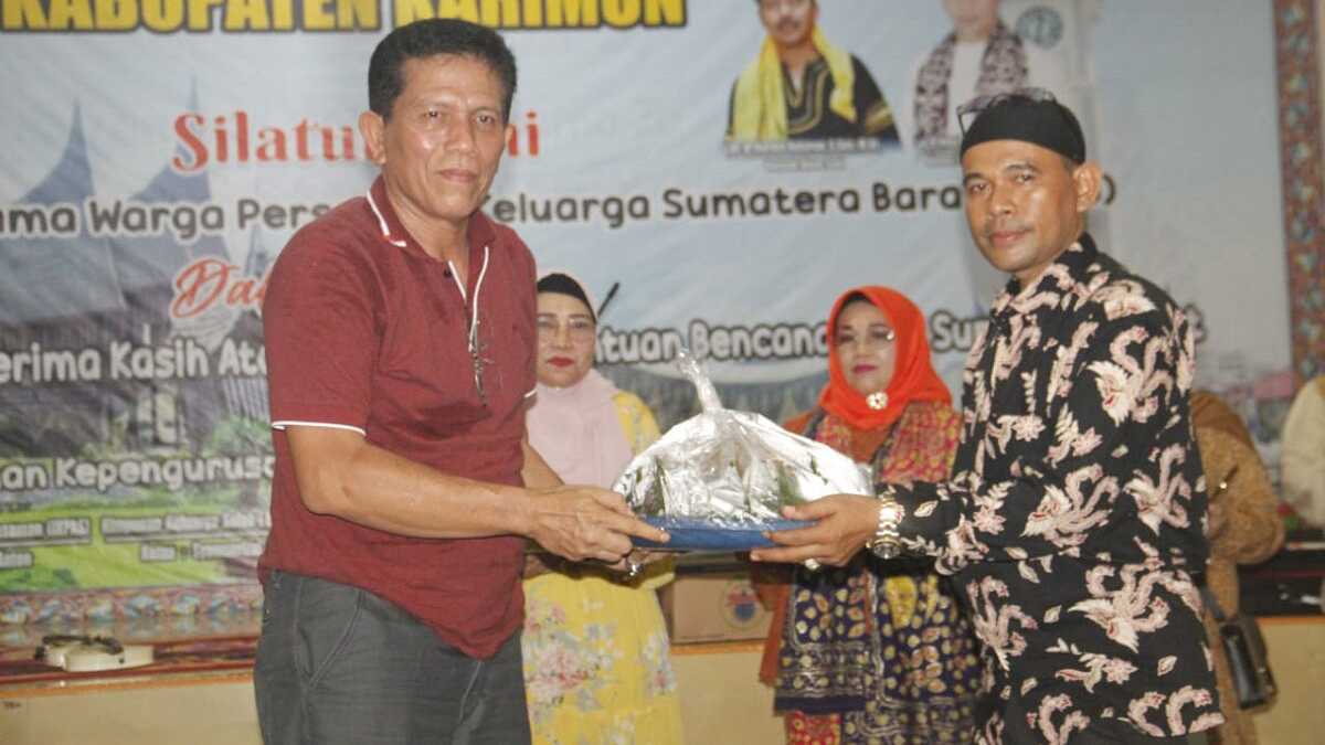 Ketua HKSS Kabupaten Karimun Syamsurizal (kanan) menyerahkan kue kepada pemenang lelang. (jurnalterkini.id/edy kencana)