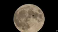 pesawat terbang di depan bulan Sebuah pesawat terbang di depan bulan di Chicago, pada 30 Agustus 2023. (Foto: AP/Kiichiro Sato)