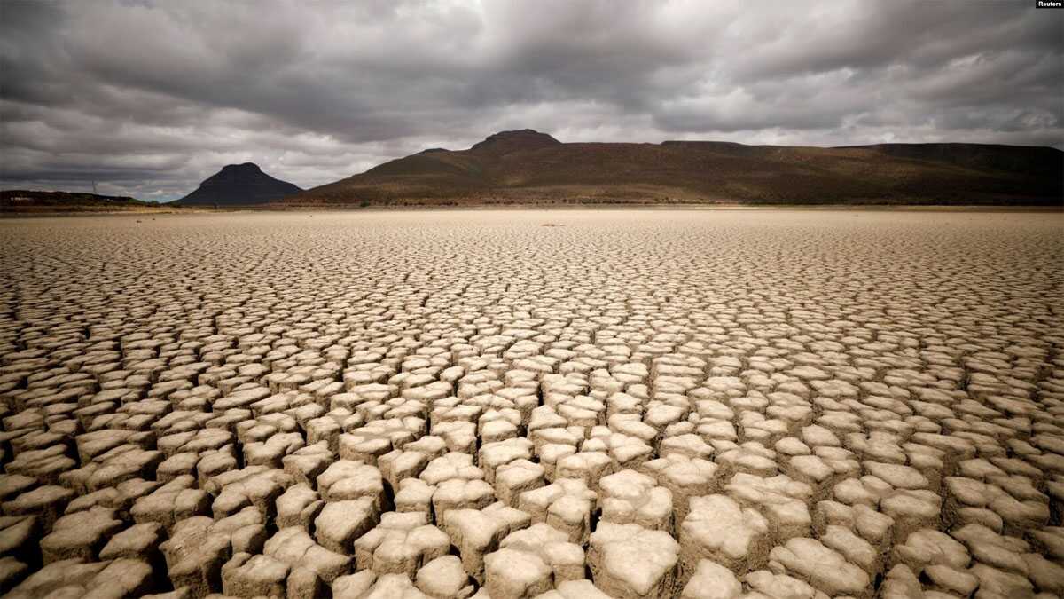Awan tebal menyelimuti Graaff-Reinet, Afrika Selatan, namun tidak menghasilkan hujan, sementara retakan terlihat pada bendungan yang mengering akibat kekeringan, 14 November 2019. (Foto: Reuters)