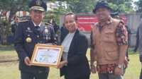 Kepala Kantor Wilayah Kemenkumham Provinsi Kepri, I Nyoman Gede Surya Mataram menyerahkan penghargaan kepada Direktur LBH SADO Linda Theresia didampingi Roy Sado, di halaman Kantor Kemenkumham Kepri, Senin (19/8/2024). (Dokumentasi pribadi)