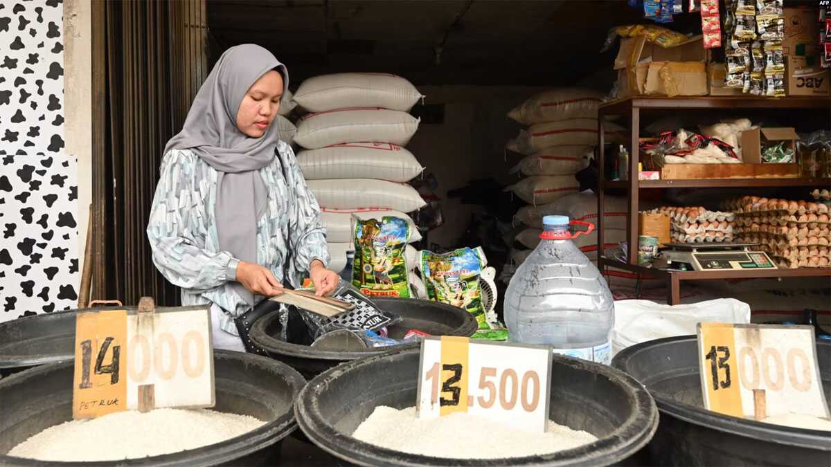 Seorang penjual menunggu pelanggan di kios beras di Jakarta pada 28 Februari 2024, di tengah lonjakan harga dan kekurangan bahan pokok. (Foto: Adek Berry/AFP)