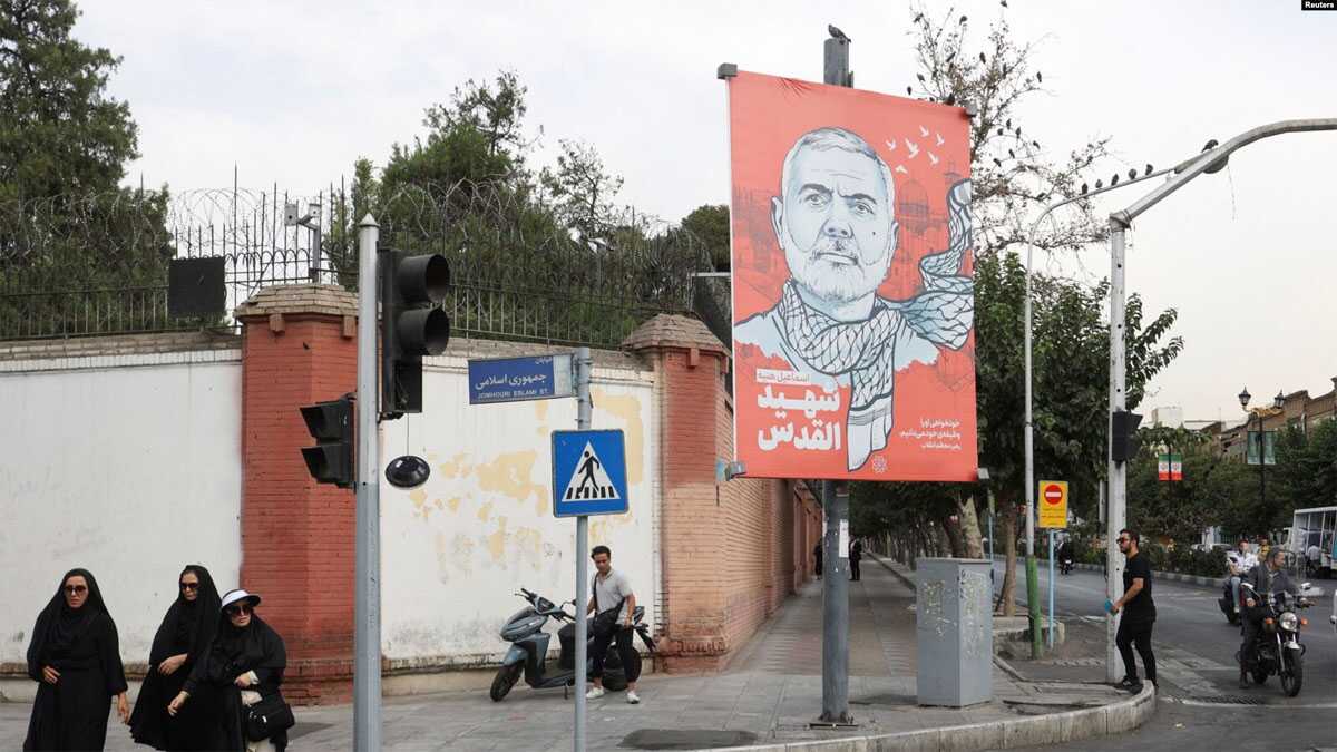 Orang-orang berjalan melewati spanduk bergambar mendiang pemimpin Hamas Ismail Haniyeh di sebuah jalan di Teheran, Iran, 12 Agustus 2024. (Majid Asgaripour/WANA (West Asia News Agency) via REUTERS)