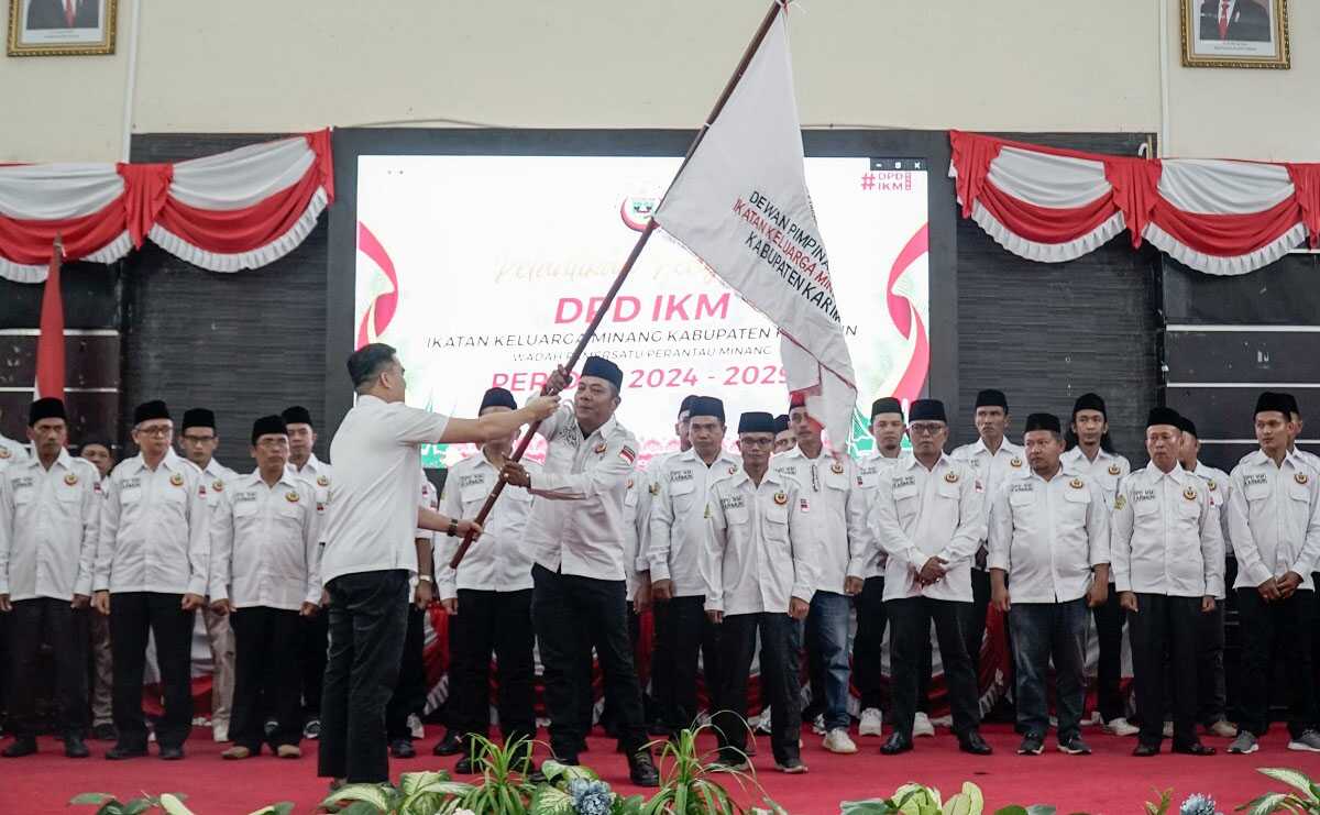Ketua DPW IKM Provinsi Kepri Momon Faulana Adinata menyerahkan pataka kepada Ketua DPD IKM Karimun Devanan Syam usai dilantik bersama jajaran kepengurusan periode 2024-2029 di Gedung Nasional Tanjung Balai Karimun, Selasa (17/9/2024). (DPD IKM Karimun)