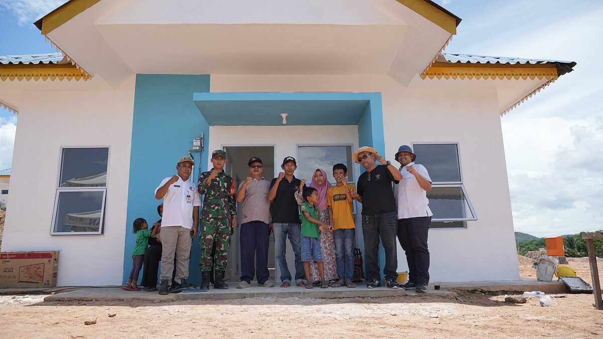 Fahrudin bersama keluarga bersama sejumlah pihak berpose di depan rumah baru di Tanjung Banun yang mulai ia tempati pada Kamis (3/10/2024). (foto: humasbpbatam)