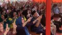Anggota DPR RI, Rohid bersama ribuan warga mengangkat tangan sembari menyimbolkan dua jari yang merupakan nomor urut Paslon di Pilkada Riau dan Pilkada Kampar yang diusung oleh Presiden terpilih Prabowo saat acara tasyakuran di desa Kubang Jaya, Rabu, (9/10/24). (JurnalTerkini.id/canggih)