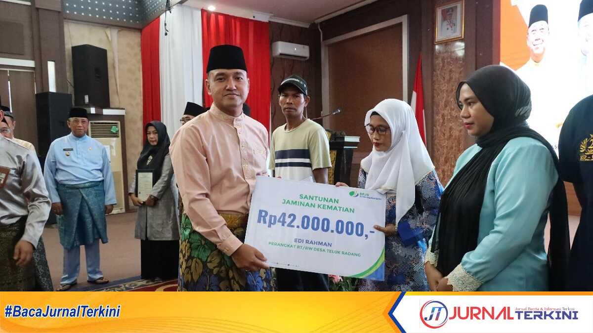 Kapolres Karimun AKBP Robby Topan Manusiwa secara simbolis menyerahkan santunan jaminan kematian BPJS Ketenagakerjaan dalam acara syukuran HUT Kabupaten Karimun yang ke-25 di Gedung Nilam Sari, Kantor Bupati Karimun pada Sabtu (12/10/2024). (JurnalTerkini.id/edy kencana)