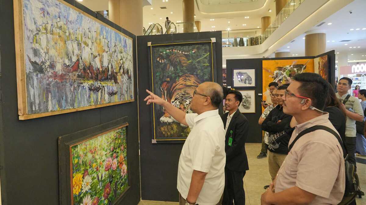 Plh. Kepala BP Batam, Purwiyanto mengamati lukisan yang dipamerkan dalam Pameran Lukisan bertema "Peran Pelaku Seni dalam Mendukung Pembangunan dan Pariwisata Batam" yang digelar di One Batam Mall, Jumat, (1/11/2024). (Foto: Humas BP Batam)