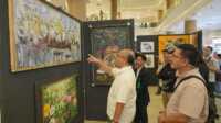 pameran lukisan hari bakti BP Batam 1 Plh. Kepala BP Batam, Purwiyanto mengamati lukisan yang dipamerkan dalam Pameran Lukisan bertema "Peran Pelaku Seni dalam Mendukung Pembangunan dan Pariwisata Batam" yang digelar di One Batam Mall, Jumat, (1/11/2024). (Foto: Humas BP Batam)