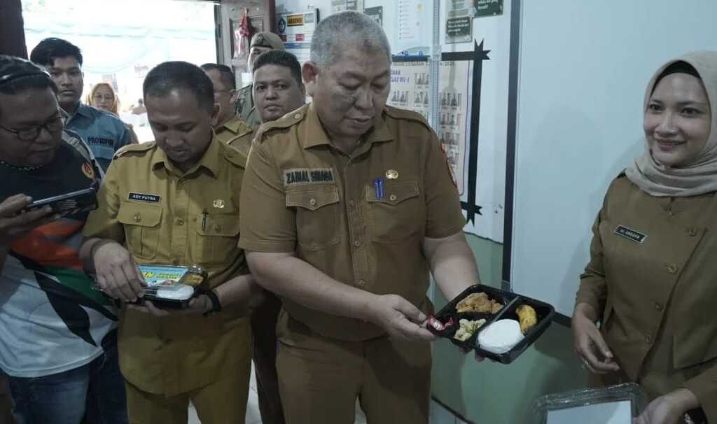 Asahan uji coba makan bergizi gratis Sekretaris Daerah Kabupaten Asahan Drs. Zainal Aripin Sinaga, MH mengikuti launching gerakan serentak uji coba makanan gratis bagi peserta didik di Kabupaten Asahan di 3 sekolah yakni UPTD SMPN 2 Kisaran, UPTD SDN 013857 Mekar Baru dan UPTD SDN 013858 Mekar Baru, Senin (09/12/2024). (Foto: Diskominfo Asahan)