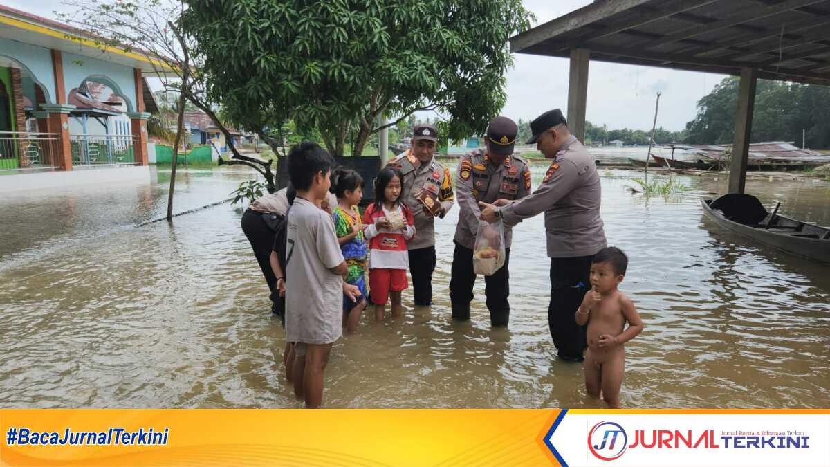 Hibur anak-anak yang terdampak banjir, Kapolsek Kampar Kiri Hilir, Iptu Irwan Fikri sambangi warga yang terdampak banjir di Desa Mentulik kecamatan Kampar Kiri Hilir, Kamis, (16/1/2025). (JurnalTerkini.id/canggih)