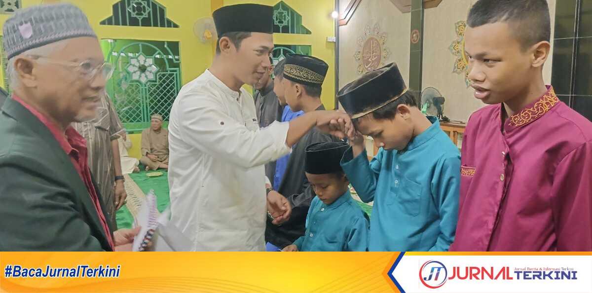 isra mikraj di Harjosari Lurah Harjosari Indra menyerahkan santunan untuk anak yatim dan yatim piatu dalam acara peringatan Isra Miraj Nabi Muhammad SAW di Masjid Al Mujahidin, Kelurahan Harjosari, Kecamatan Tebing, Kabupaten Karimun, Kepulauan Riau, Rabu (29/1/2025) malam. (JurnalTerkini.id/edy kencana)