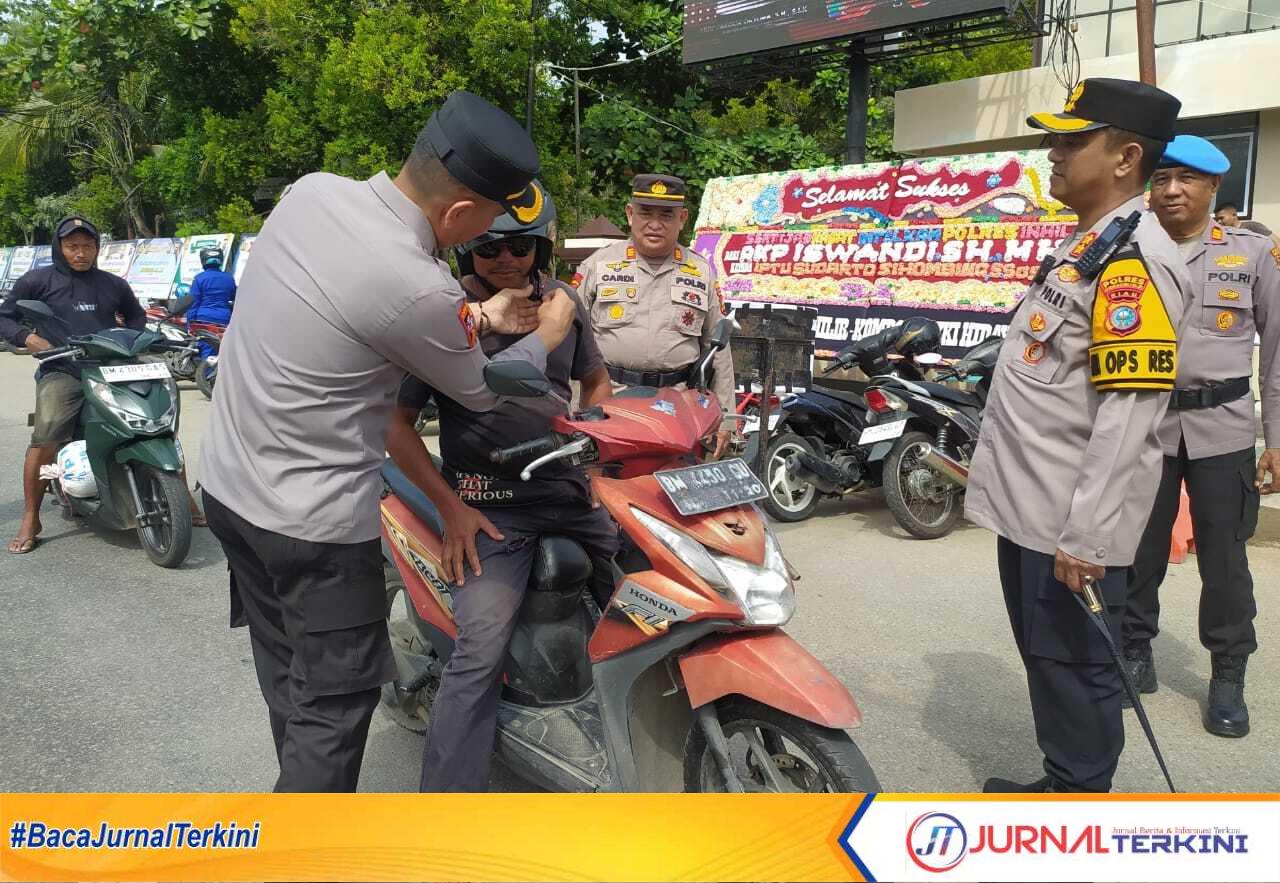 Kapolres Inhil AKBP Farouk Oktora saat memberikan helm Gratis kepada pengendara motor dalam rangka lanjutan Operasi Keselamatan Lancang Kuning 2025. (Humas polres Inhil)