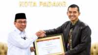 Wawako Padang, Maigus Nasir Menyerahkan Penghargaan Kepada Kepala Kantor BPJS Kesehatan Cabang Padang, Fauzi Lukman Nurdiansyah di Gedung MPP Kota Padang. (JurnalTerkini.id/Amryan)