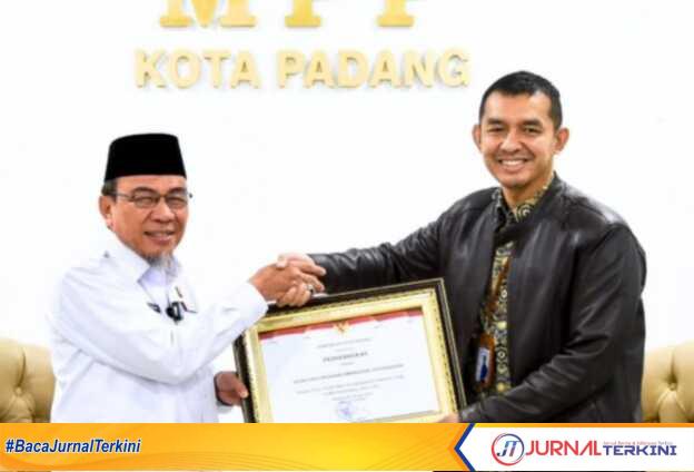 Wawako Padang, Maigus Nasir Menyerahkan Penghargaan Kepada Kepala Kantor BPJS Kesehatan Cabang Padang, Fauzi Lukman Nurdiansyah di Gedung MPP Kota Padang. (JurnalTerkini.id/Amryan)